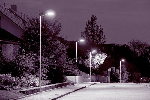 Leere Straße und Bürgersteig mit Laternen bei Nacht