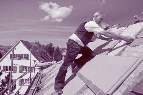 Mann saniert ein Dach