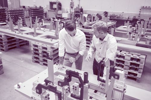 Zwei junge Männer besprechen sich in einer Produktionsstätte