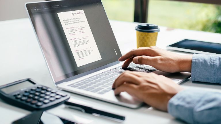 Eine Person bedient einen Laptop, auf dem ein L-Bank-Dokument zu sehen ist
