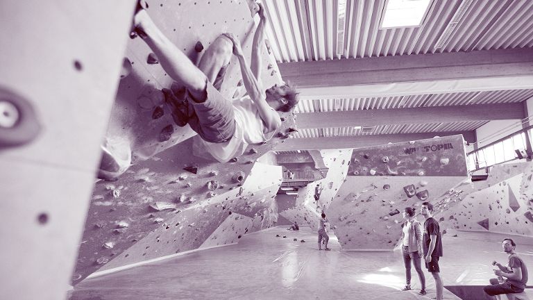 Eine Person bouldert in der Kletter- und Boulderhalle The Rock.